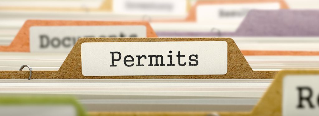 Close‑up of a filing tab labeled “Permits,” representing documentation and compliance needed for work permit Guyana processes, including visa and immigration paperwork. 